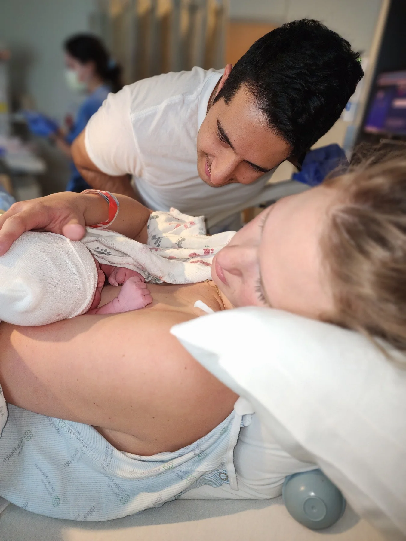 Partner gazing at newborn resting on the mother